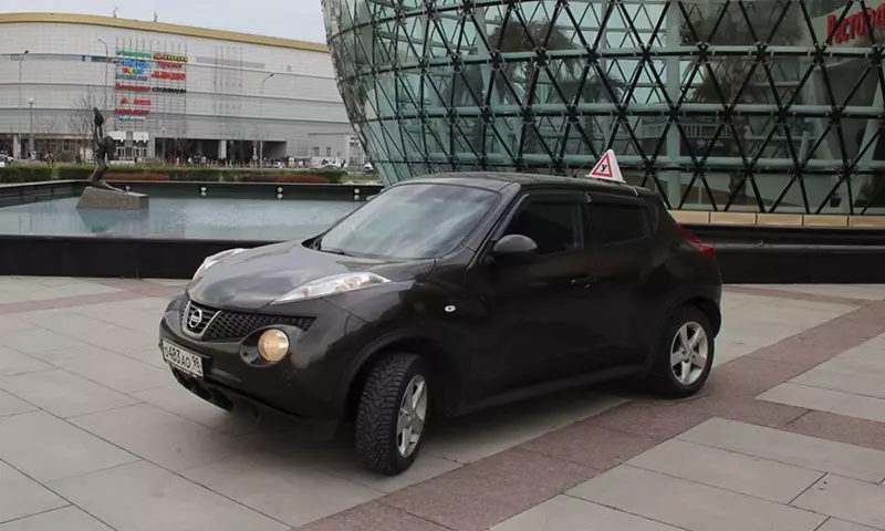 Тёмный Nissan Juke с учебным знаком на крыше