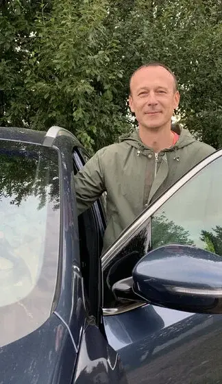 Инструктор автошколы YOU WILL DRIVE рядом с автомобилем